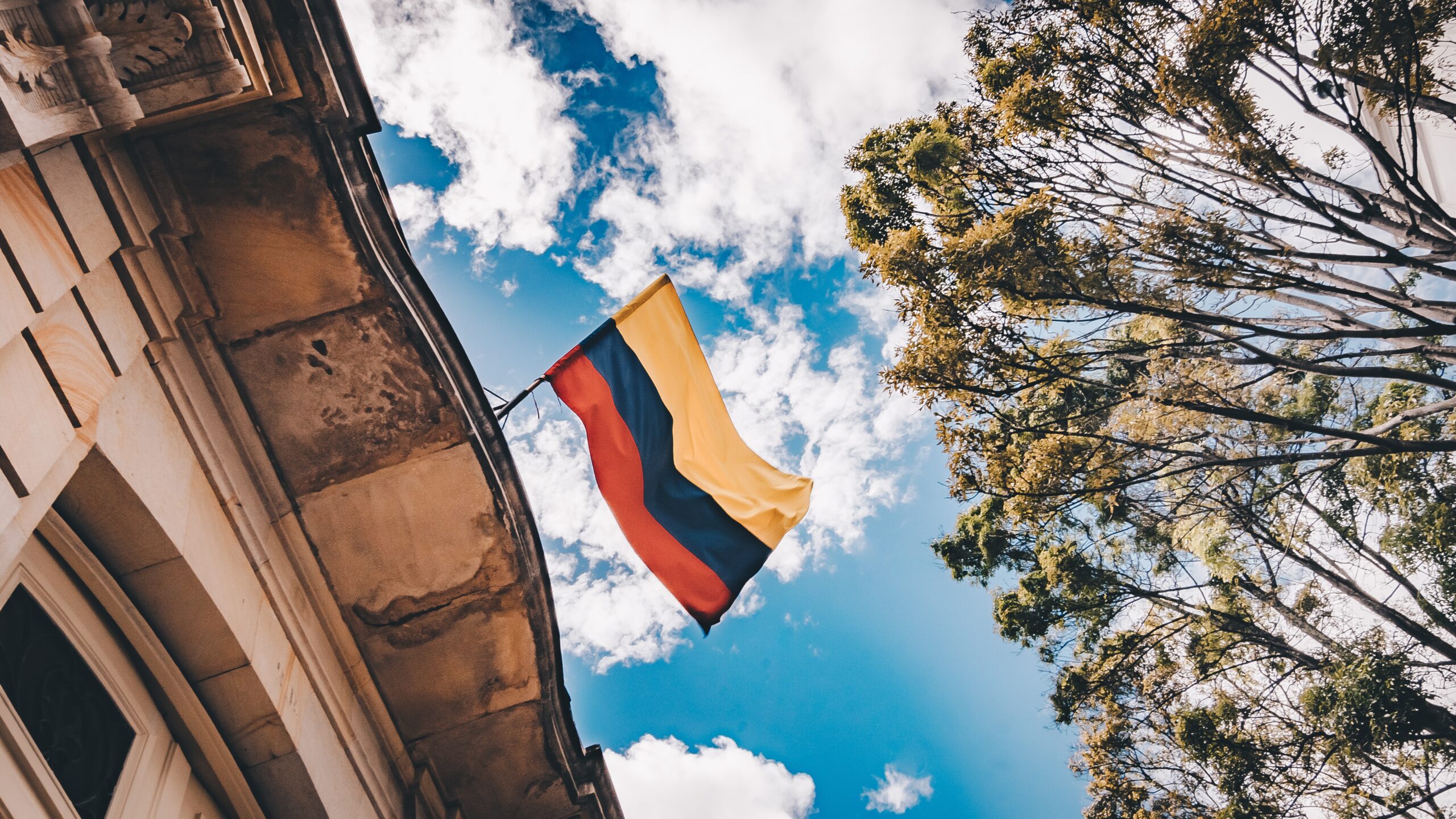 A Colombian flag over a rooftop.