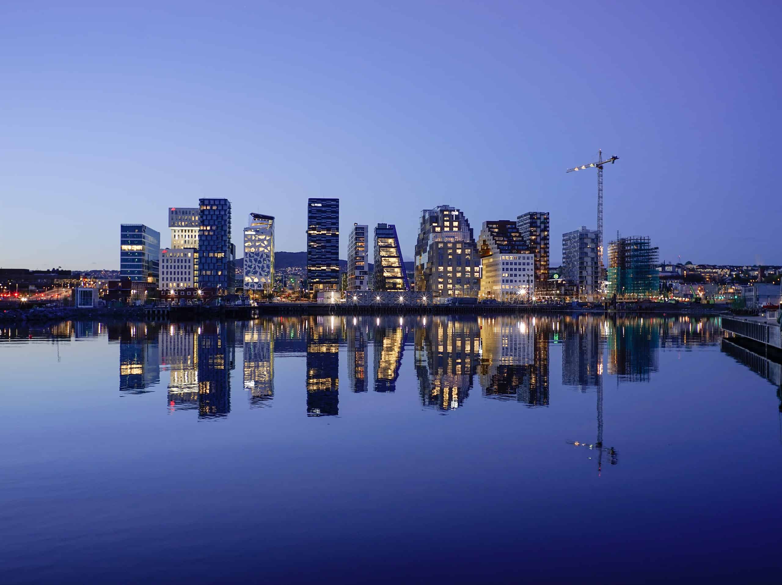 The Oslo skyline in a reflection at night.