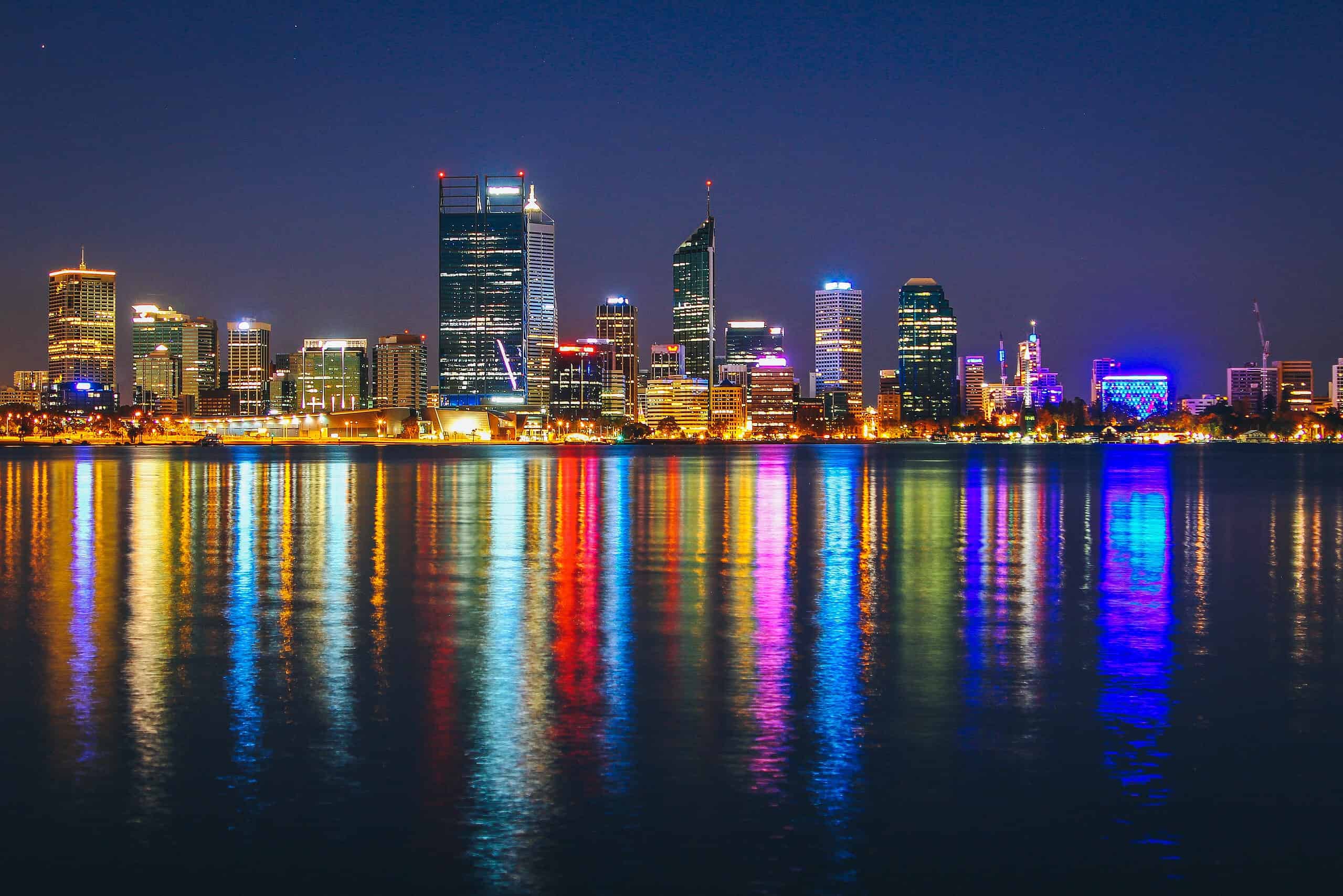 The Perth Australia skyline lit up and reflecting off the water.